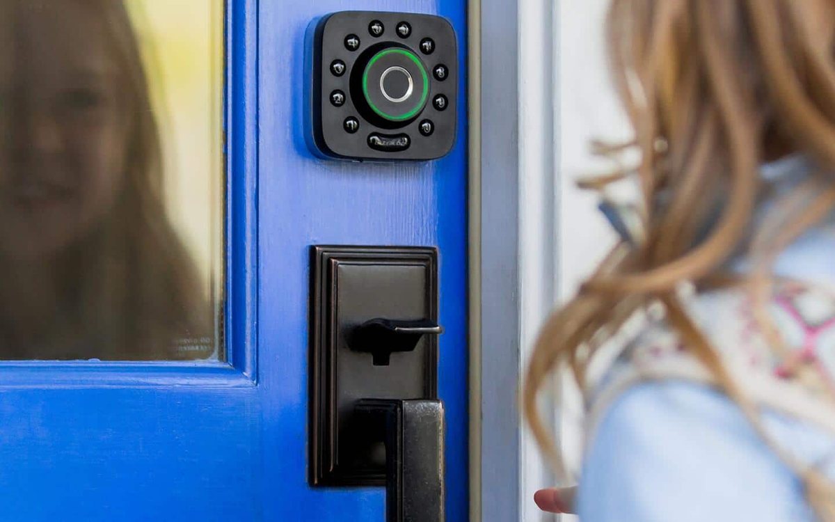Homeowner unlocking a front door with a smart lock