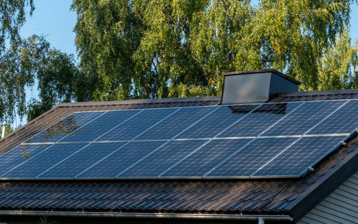 Solar panels installed across a residential roof against a clear sky